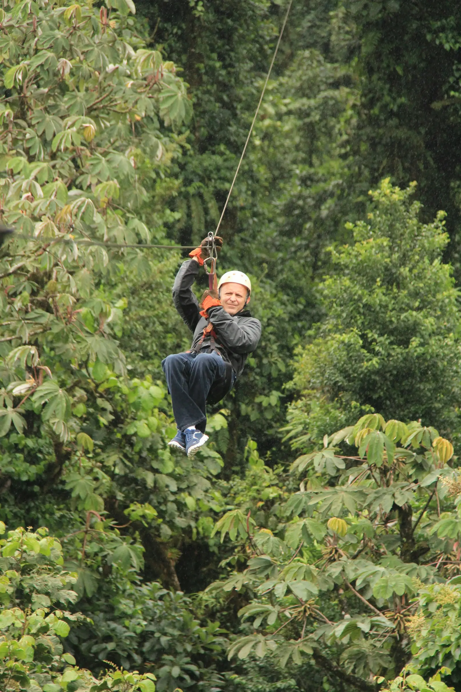 Traveler ziplining through the forest canopy in Monteverde