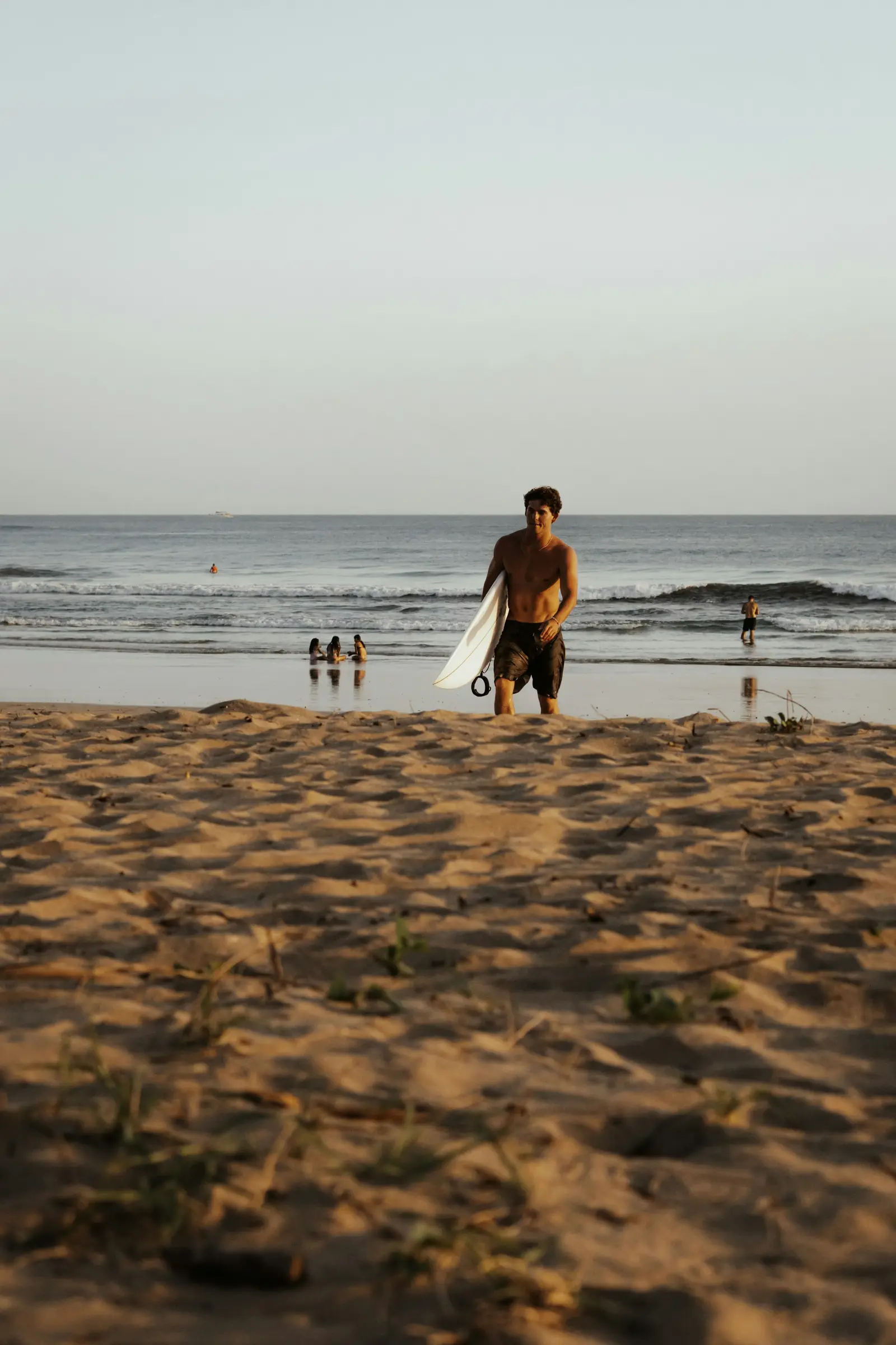 Surfer walking out of the Pacific at Tamarindo Beach